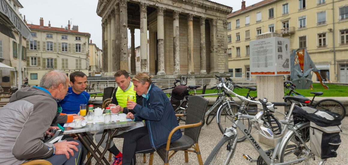 Personnes buvant un café avec leur vélo devant le Temple d'Auguste et de Livie