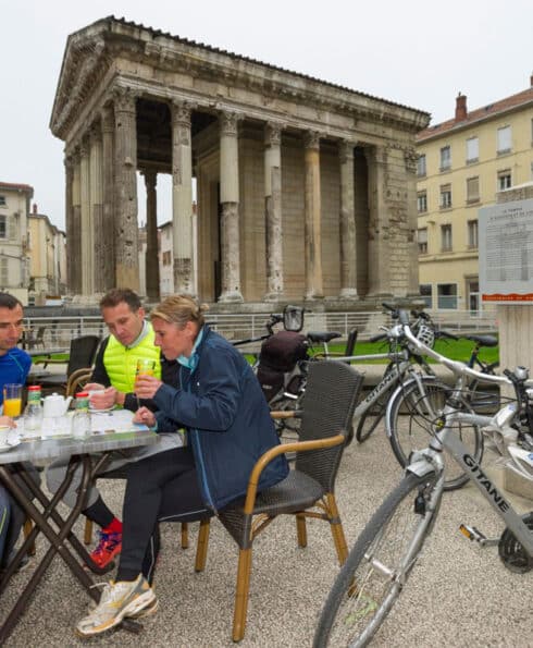 Personnes buvant un café avec leur vélo devant le Temple d'Auguste et de Livie