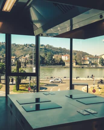Espace de cuisine professionnelle avec baie vitrée donnant sur le Rhône