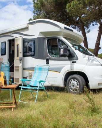 Camping car en plein air avec une guitare sur une chaise de camping