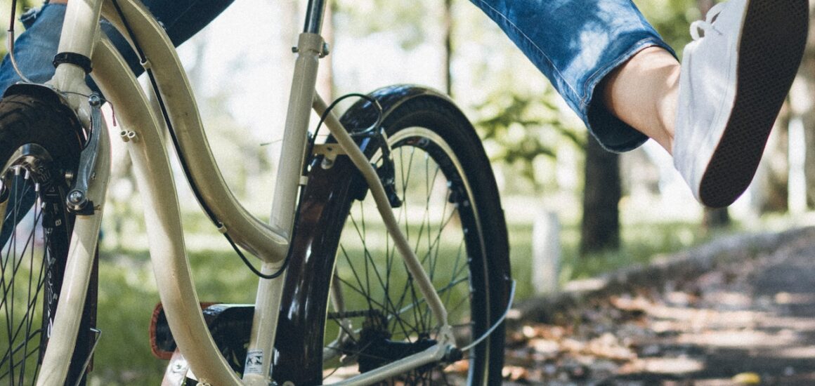 Jeune femme à vélo levant les jambes