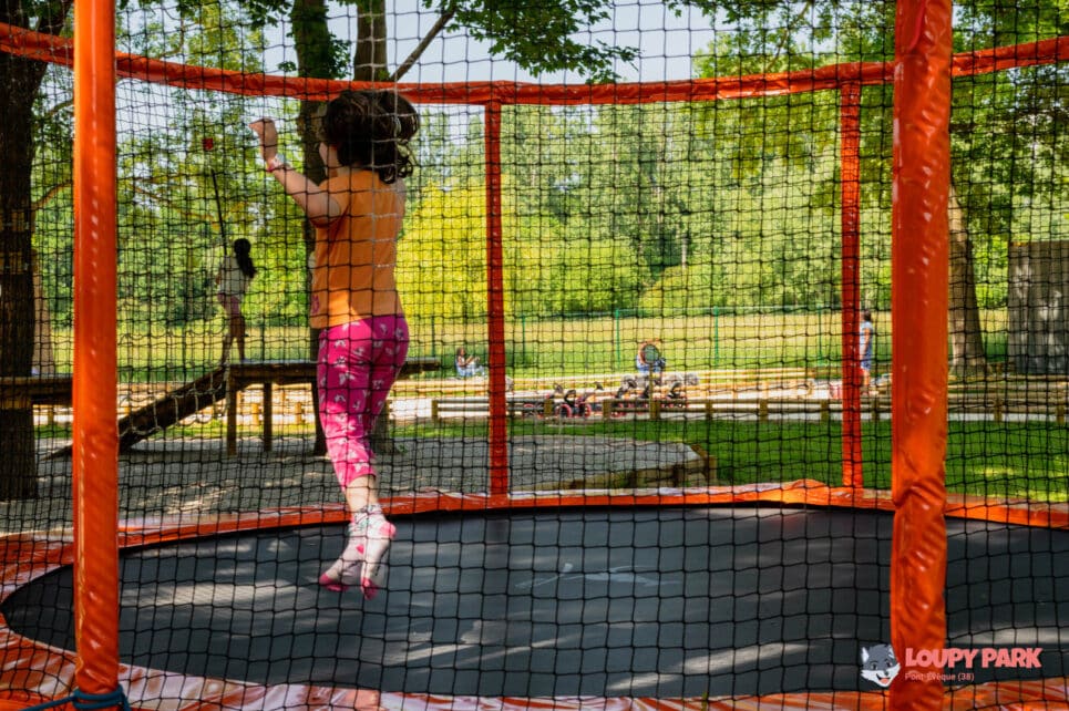 Petite fille sautant sur un trampoline, les cheveux au vent en vacances près de Lyon