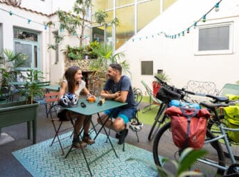 Couple d'amoureux dans la cour d'un hôtel avec leurs vélos